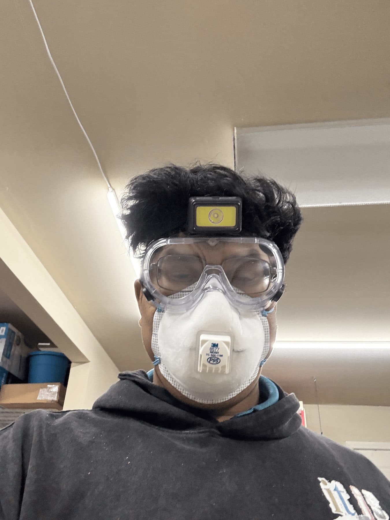 In safety goggles, respirator, and headlamp in the shop